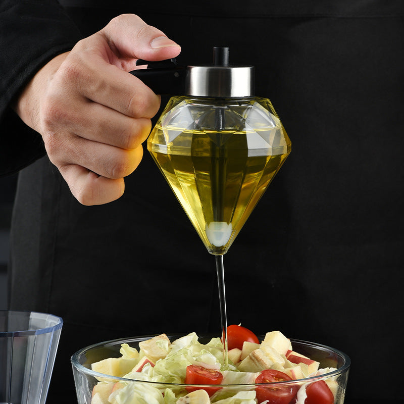 Diamond-shaped olive oil dispenser being used to drizzle oil over a salad.