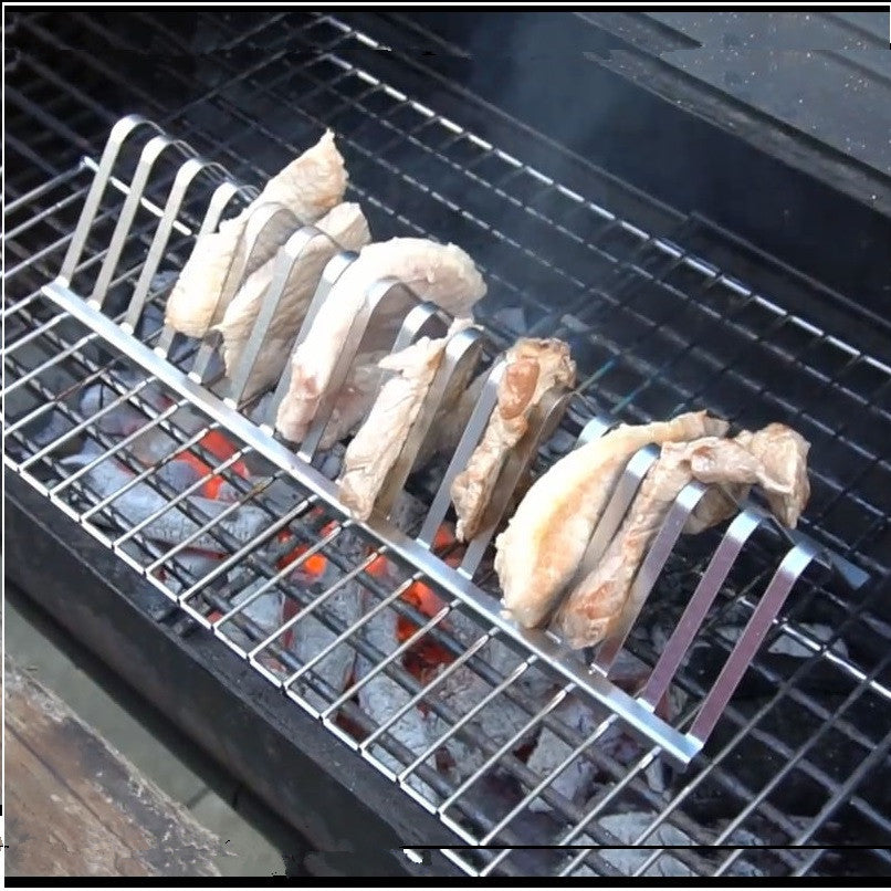 Metal grill rack with chicken wings on a barbecue grill