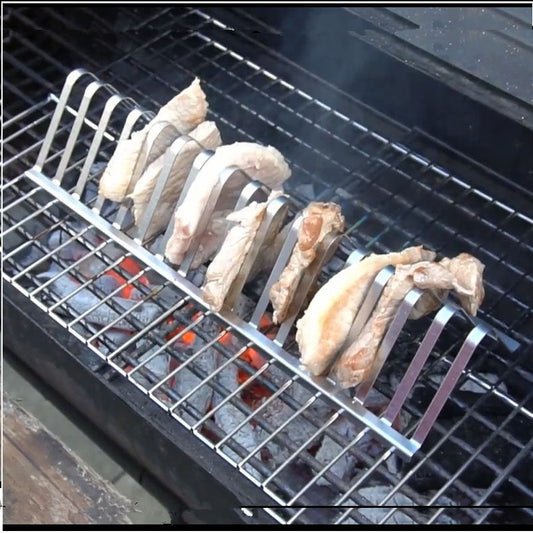 Metal grill rack with chicken wings on a barbecue grill