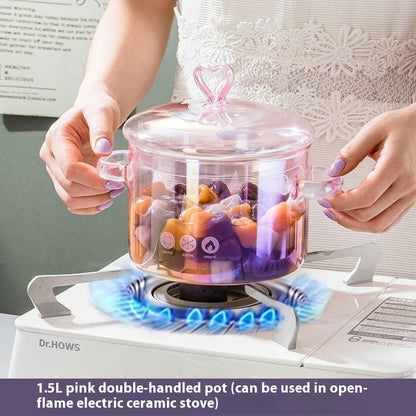 Person using a pink double-handled pot on an electric stove with colorful contents inside.