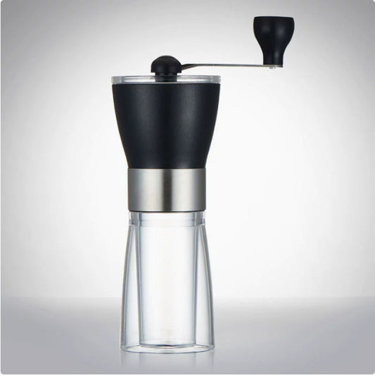 Black and silver manual coffee grinder on a gray background