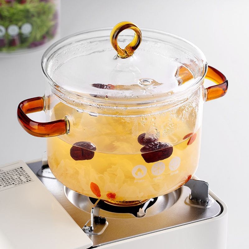 Clear glass pot with amber handles on a stove