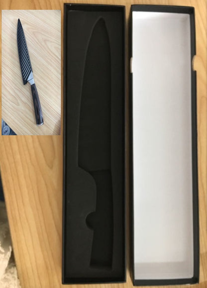 Knife with a black handle and blade in a black box on a wooden surface.