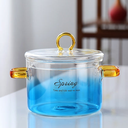 Clear glass jar with gold handles and a blue gradient, featuring the word 'Spring'.