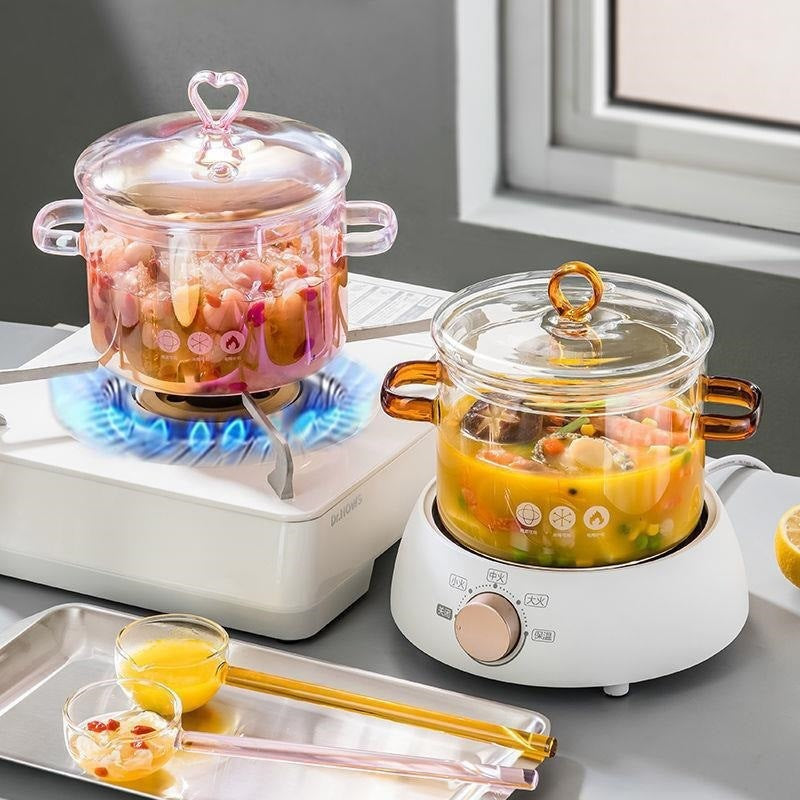 Glass cookware on a stove and hot pot with food inside, on a kitchen counter.